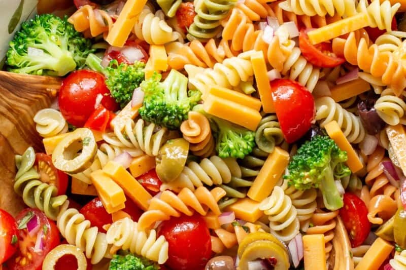 An overhead shot of a big bowl of pasta salad with tomatoes and broccoli