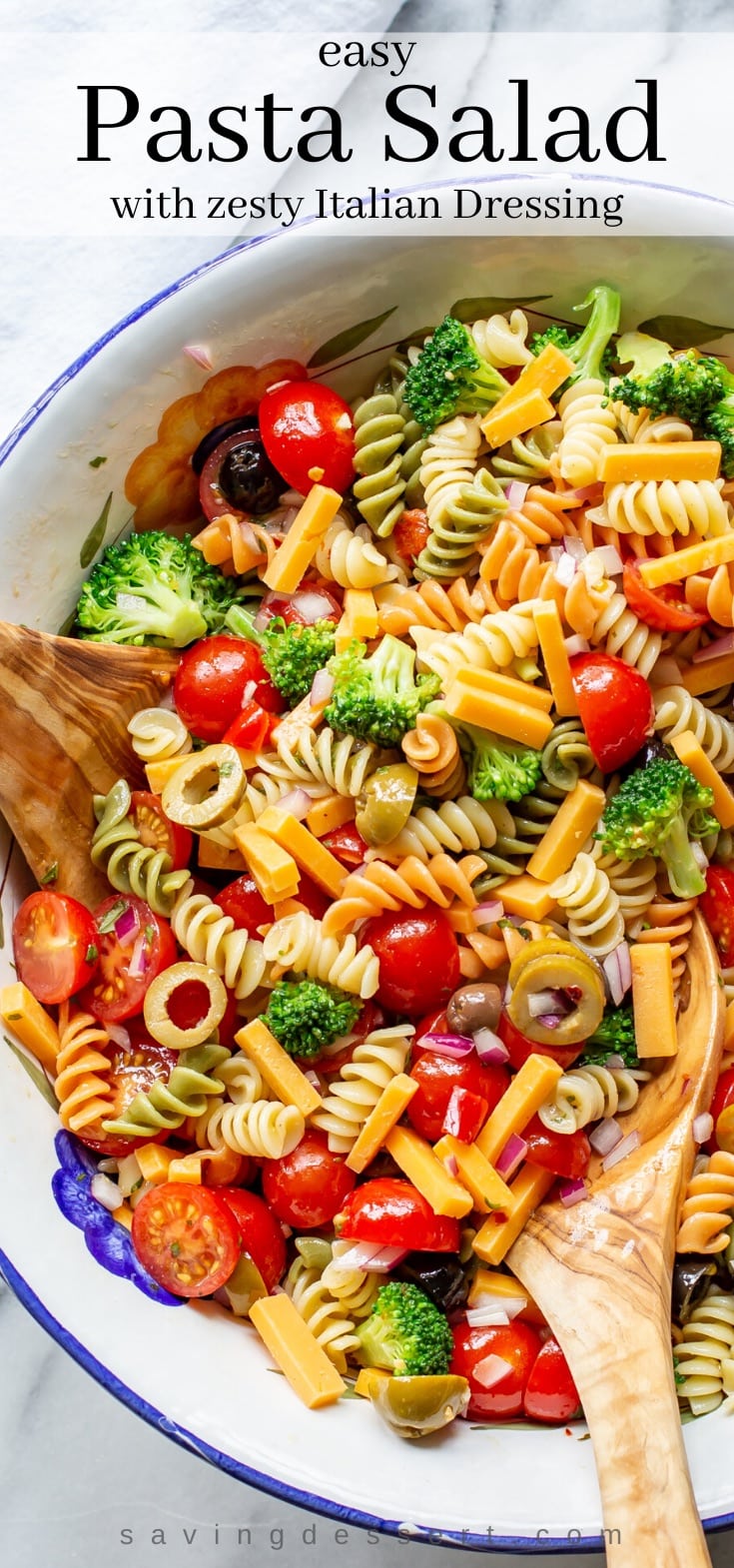 A large bowl of pasta salad with cheese, tomatoes and broccoli