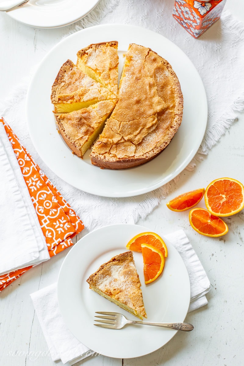 An overhead view of a sliced Orange Olive Oil Cake with sliced Cara Cara oranges