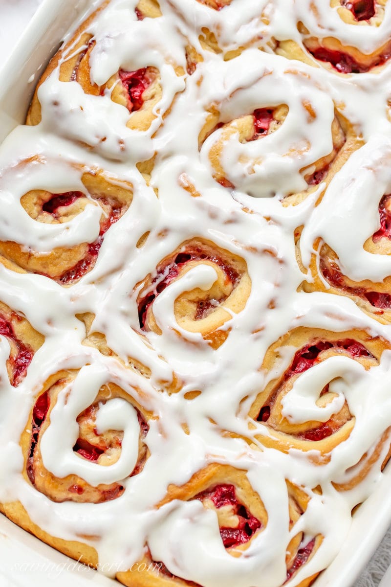A close up of a pan of Strawberry Sweet Rolls with cream cheese icing