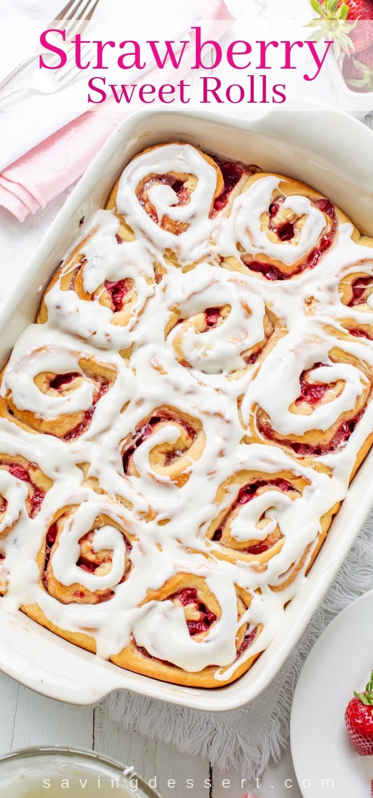 A pan of Strawberry sweet rolls with cream cheese icing