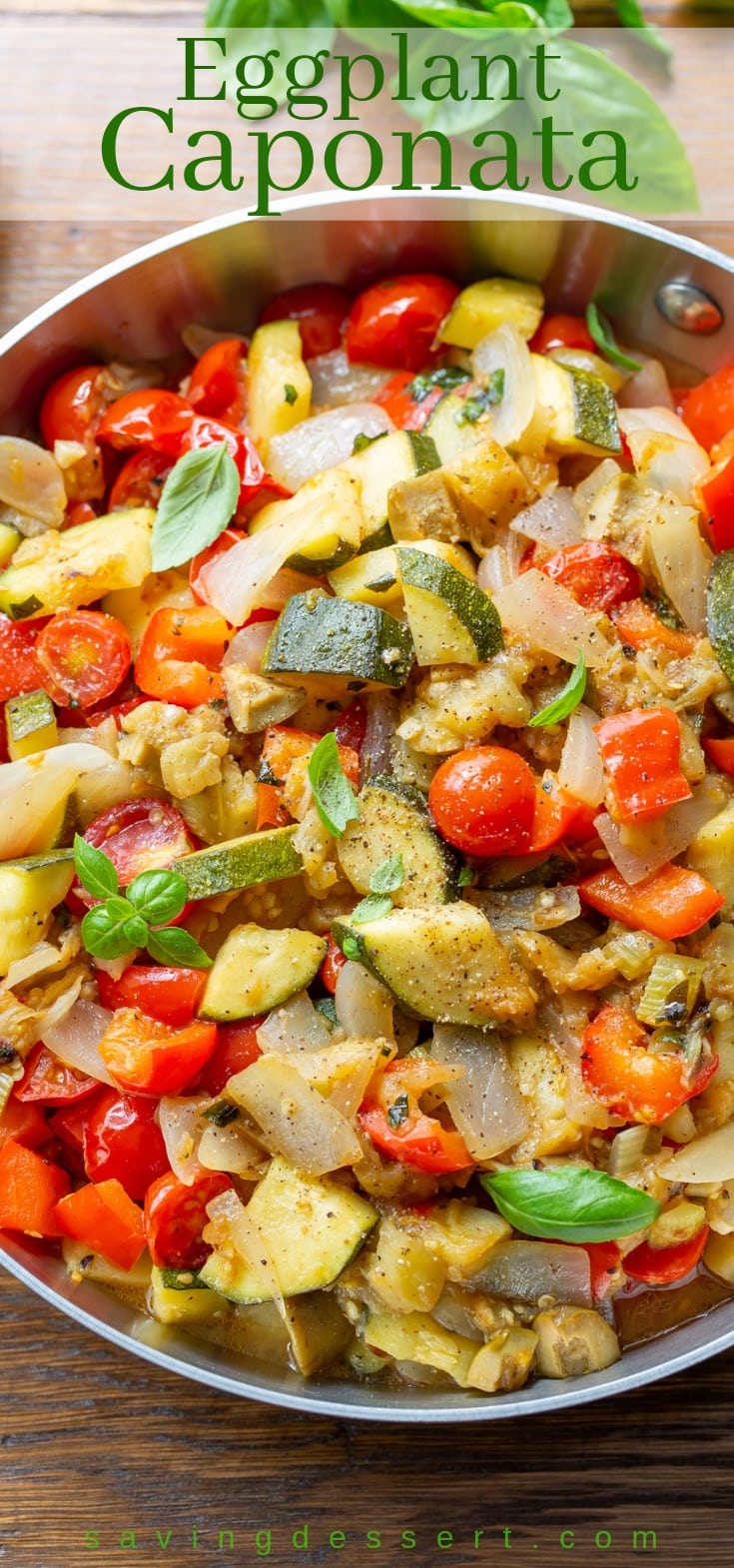 A skillet with eggplant caponata with zucchini, onions, peppers and fresh basil