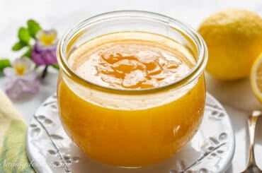 A jar of lemon curd on a plate.