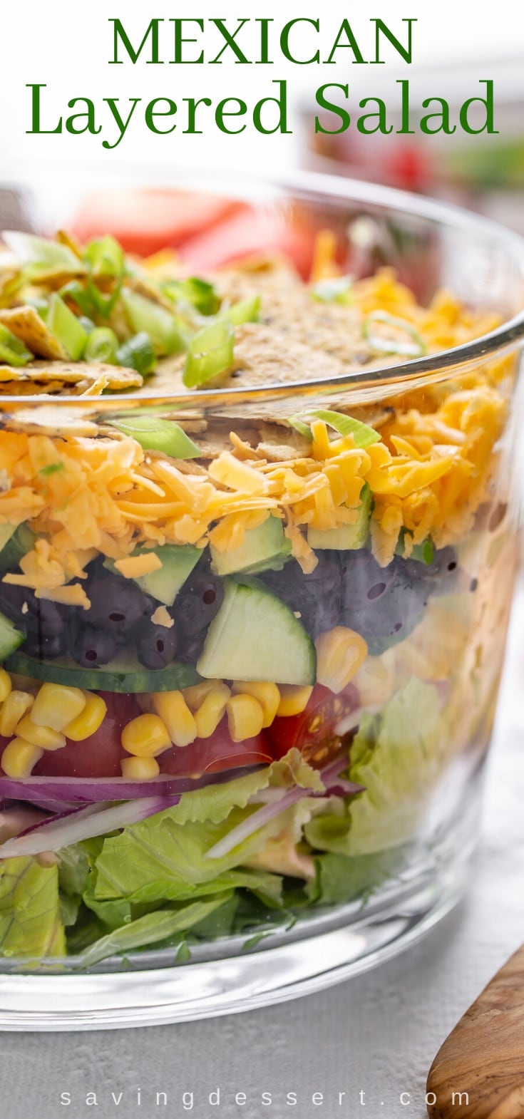 A trifle bowl filled with Mexican Layered Salad with chips on top