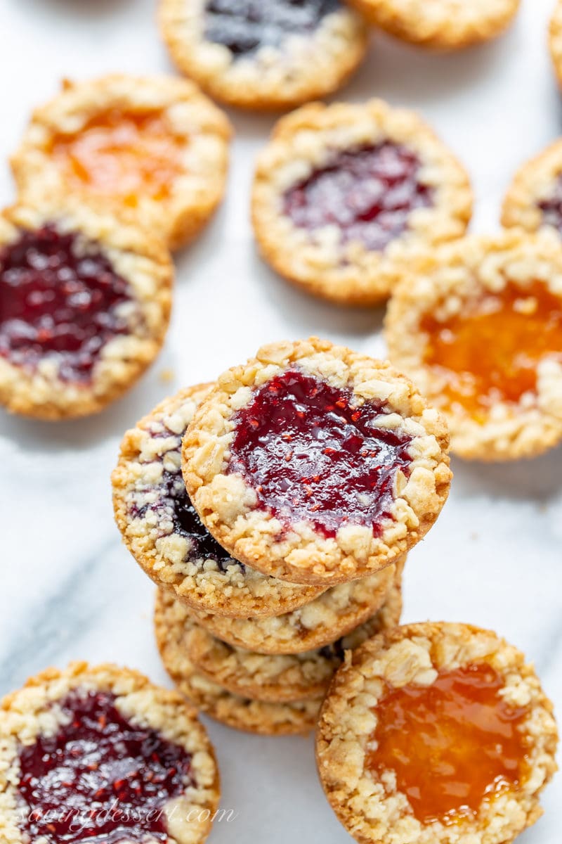 Oatmeal Jammys in a stack with apricot, raspberry and blueberry jam in the middle