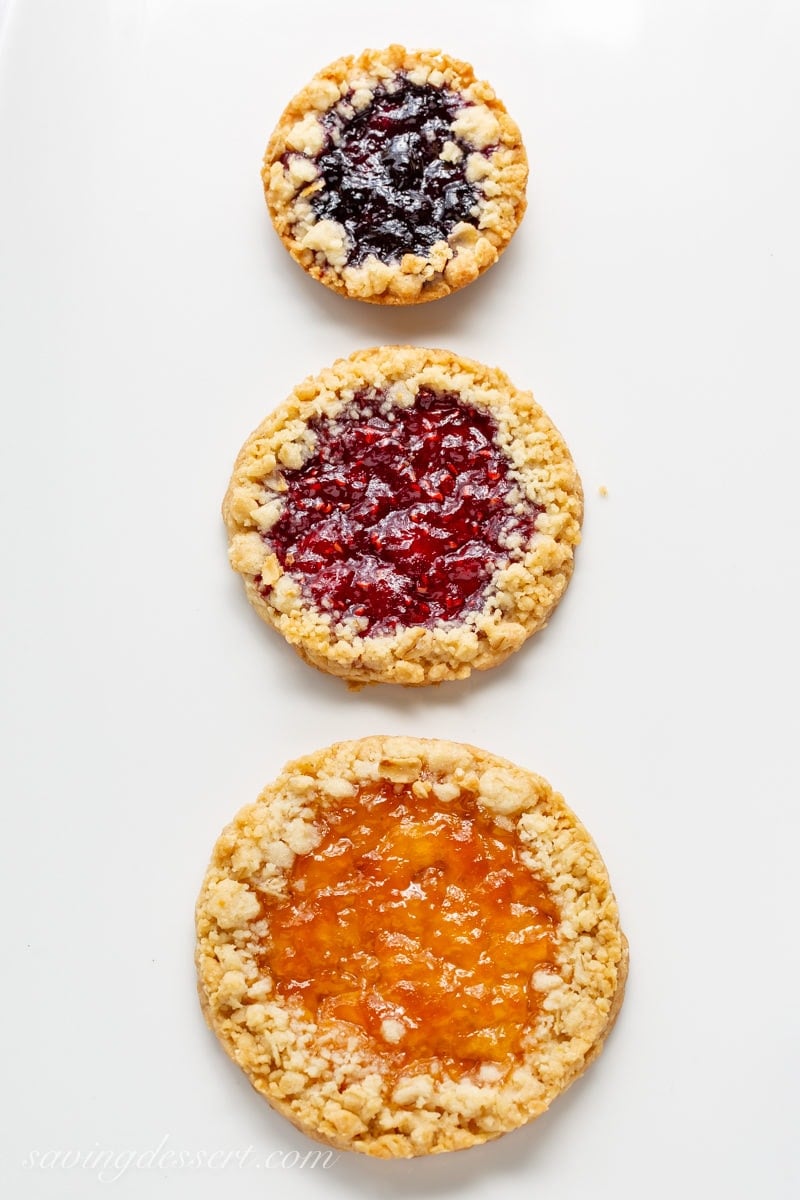 Three Oatmeal Jammy cookies in a line made in different sizes with different jams