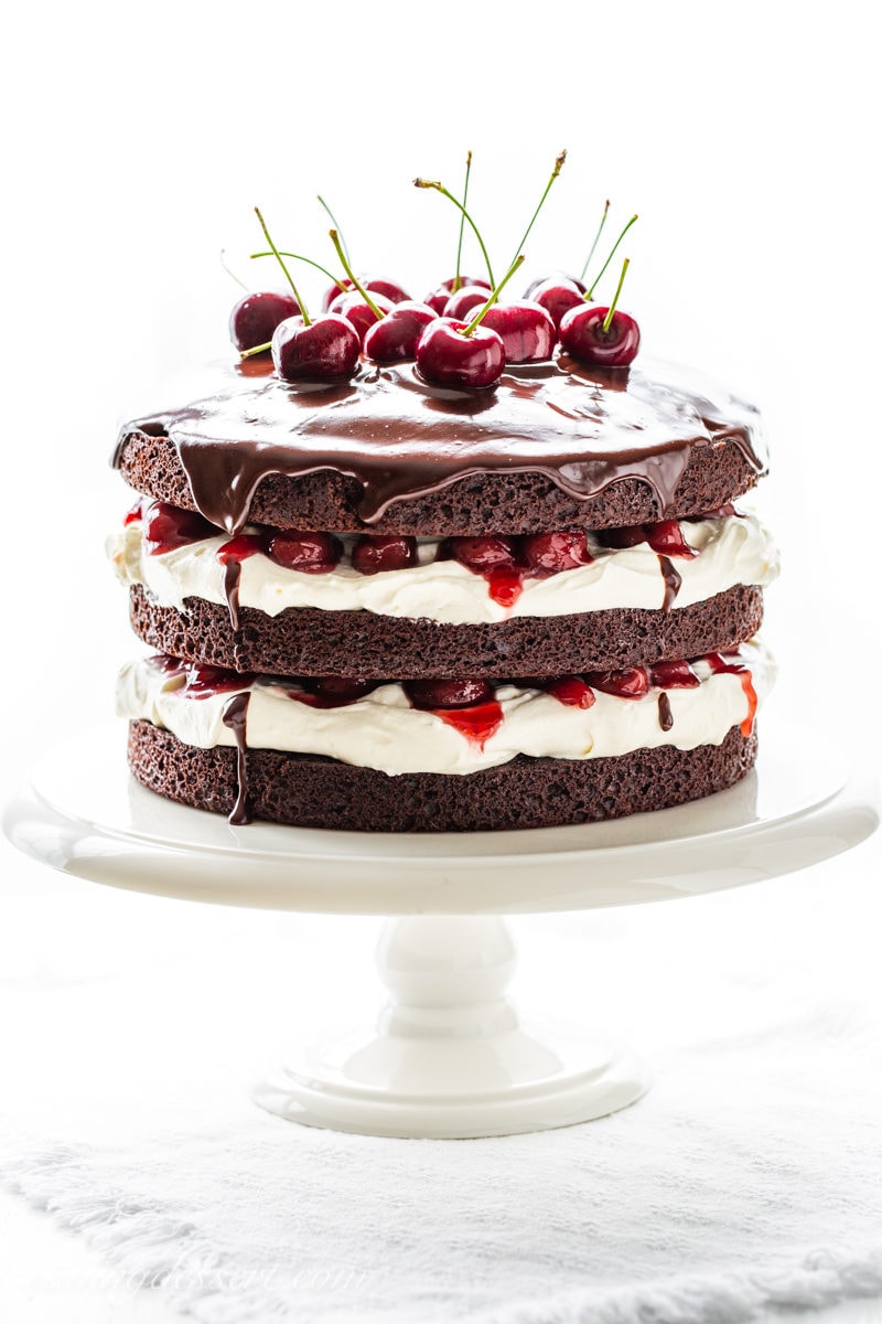 A three layer 'naked' Black Forest Cake with a whipped cream filling and fresh cherry garnish