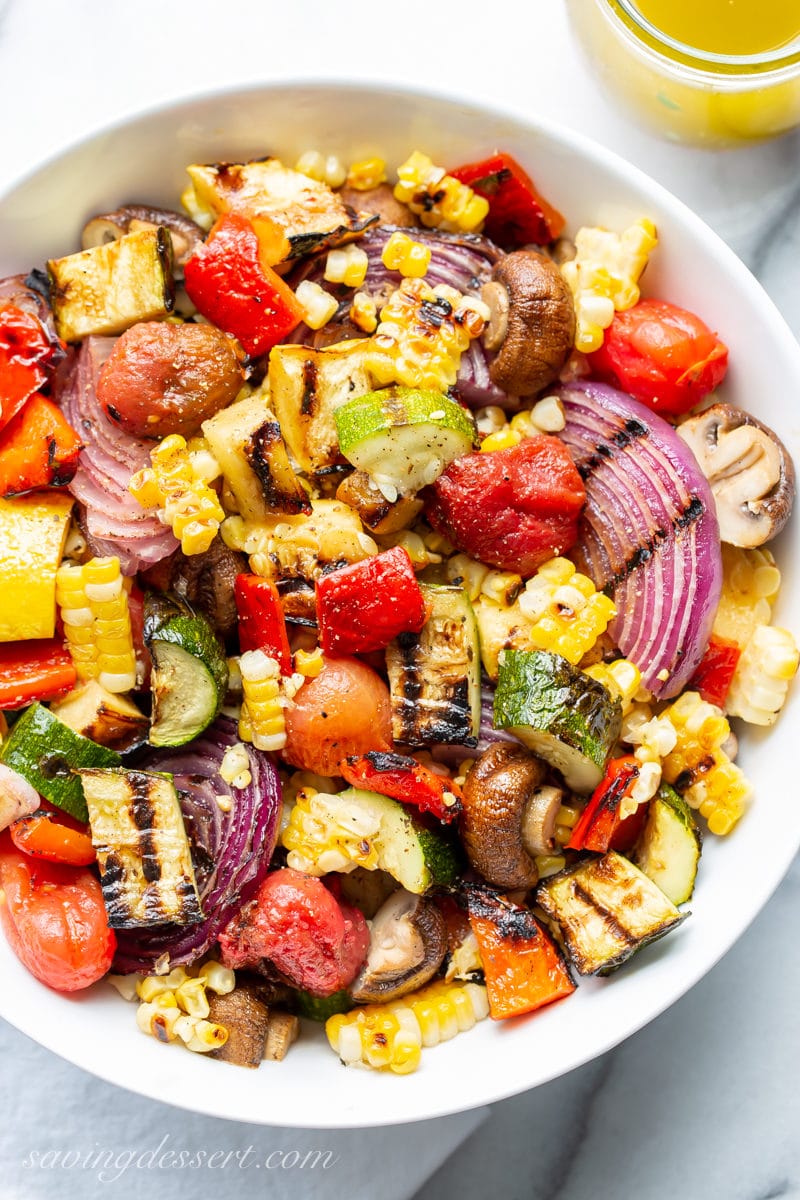 A bowl of chopped grilled vegetables with eggplant, onion, corn and squash