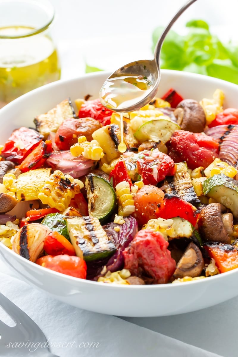 A bowl of chopped grilled vegetable including zucchini, corn, mushrooms and peppers