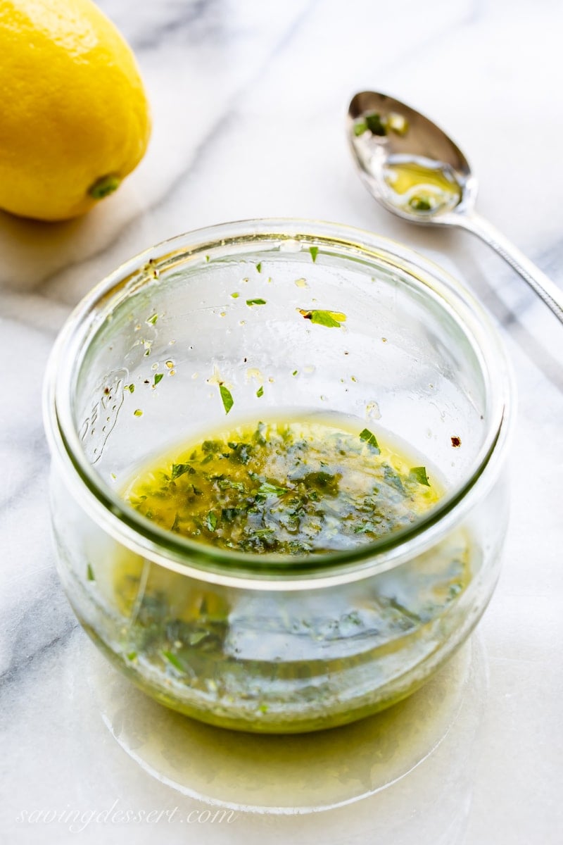 A jar of lemon and herb marinade for grilled salmon