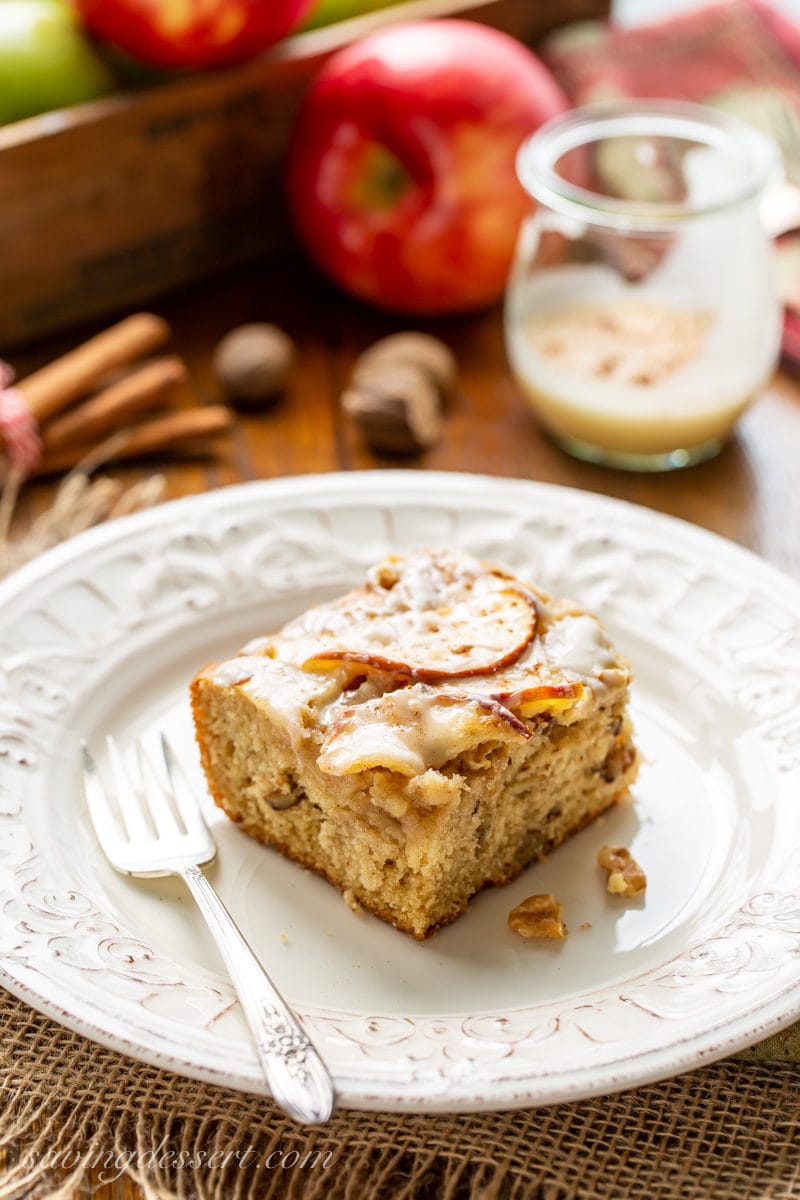 A piece of apple sheet cake with walnuts and sliced apples on top