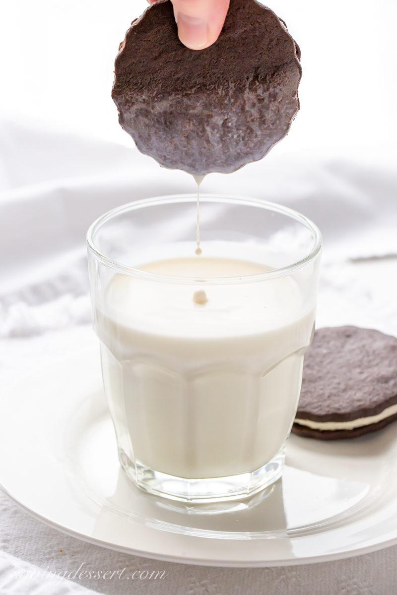 A chocolate sandwich cookie being dipped in a glass of milk - faux Oreos!