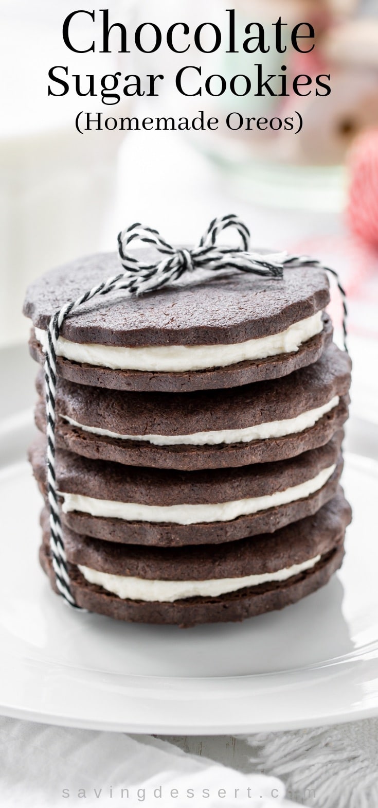 A stack of chocolate sugar cookies with a vanilla cream filing wrapped up with a black and white string
