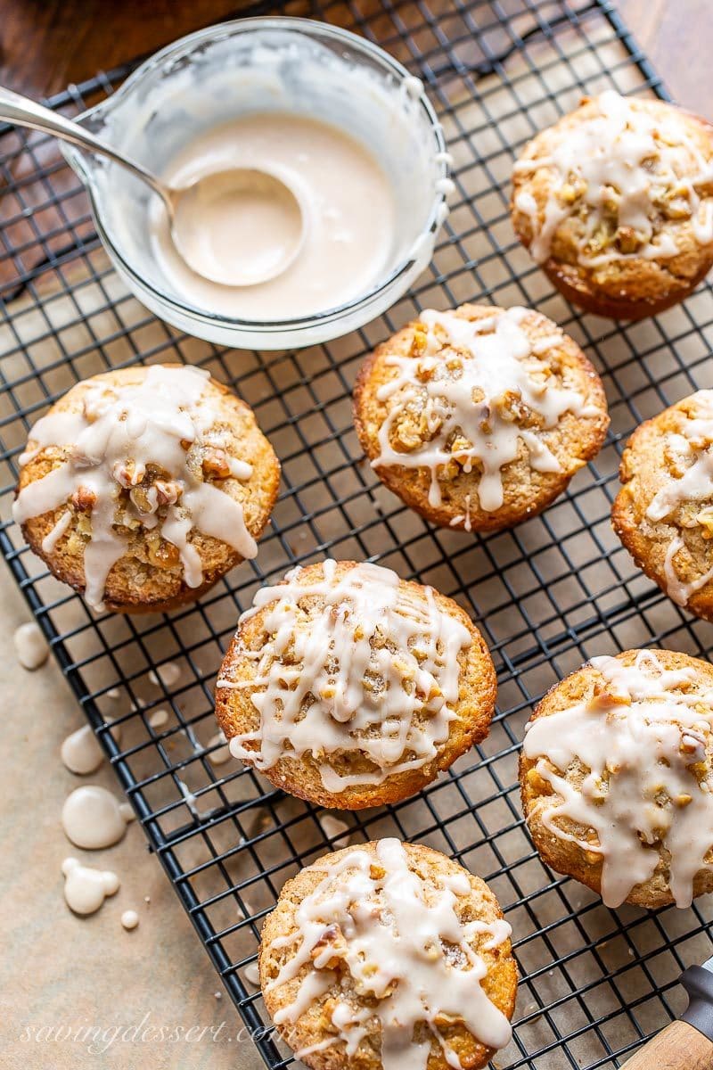 An overhead photo of a cooling rack of cinnamon apple muffins drizzled with apple cider glaze