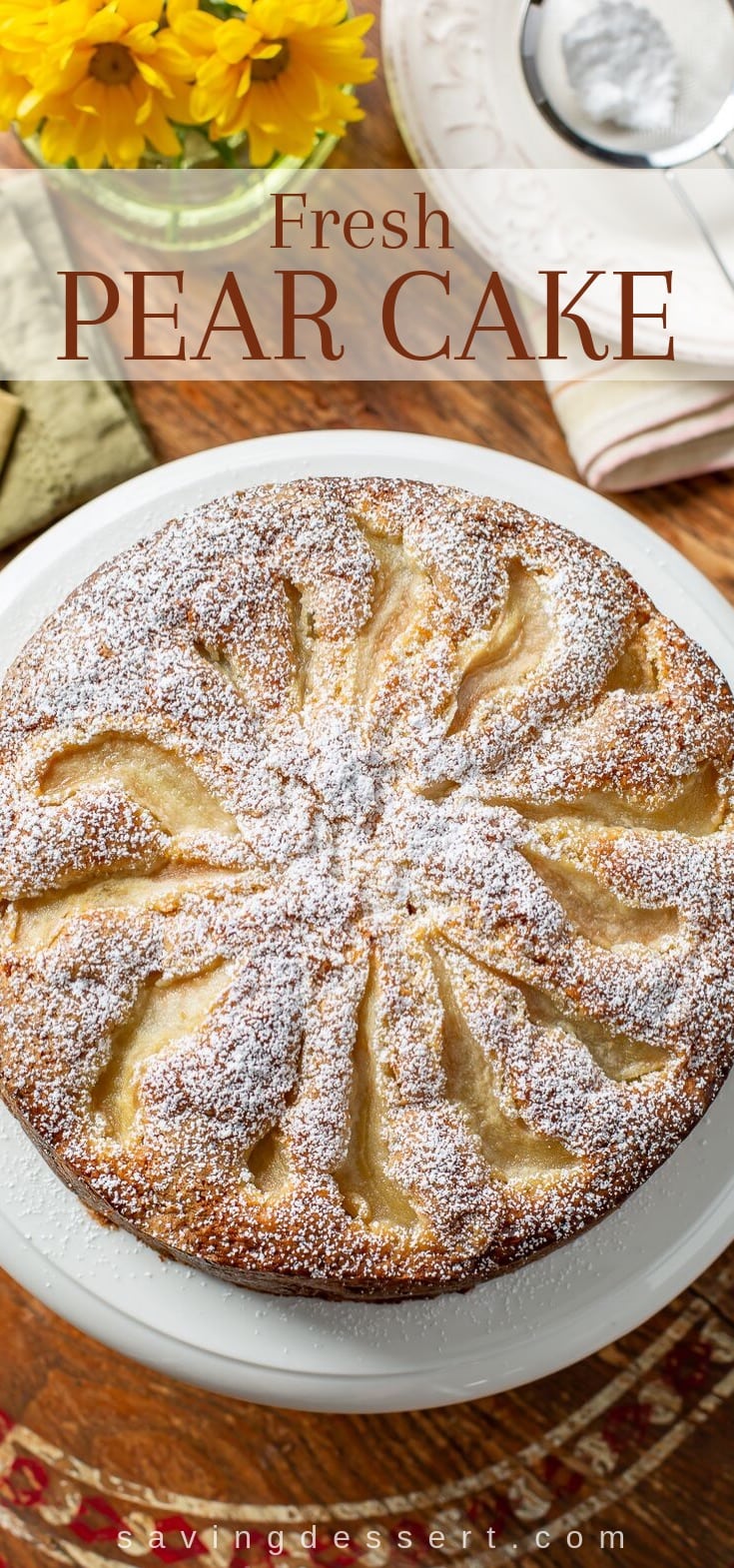A fresh pear cake with sliced pears and powdered sugar on top