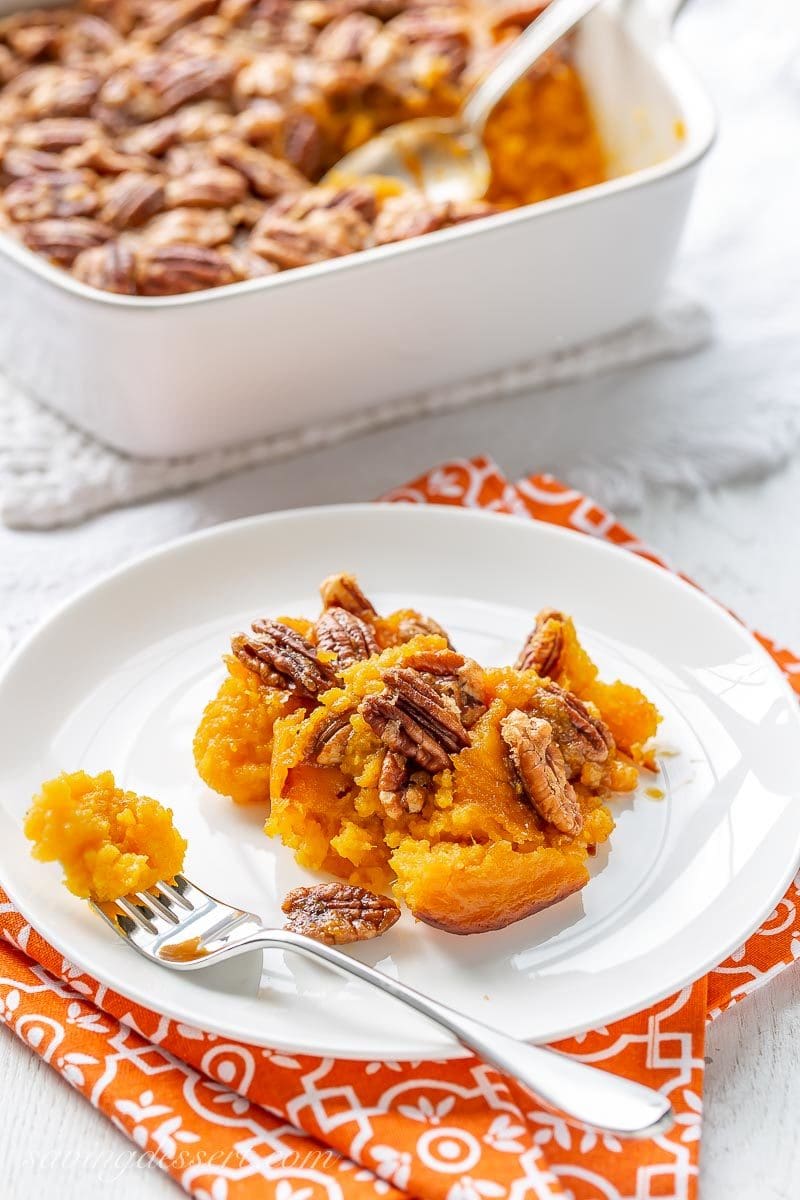 A plate of butternut squash casserole topped with pecans
