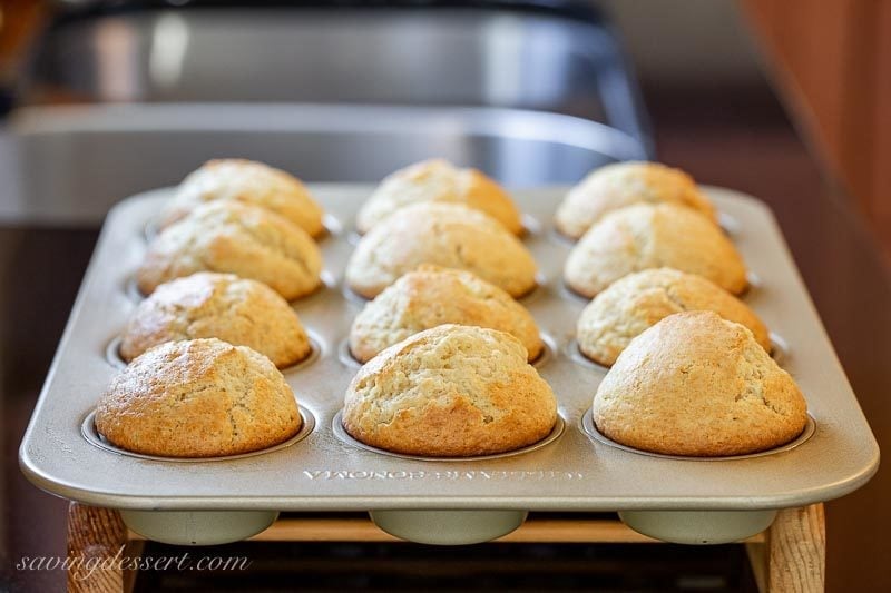 Muffins with big domed tops in a muffin pan fresh from the oven