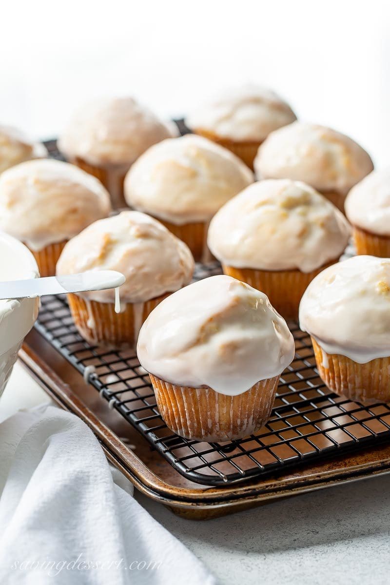 Big domed muffins with a vanilla glaze on a cooling rack