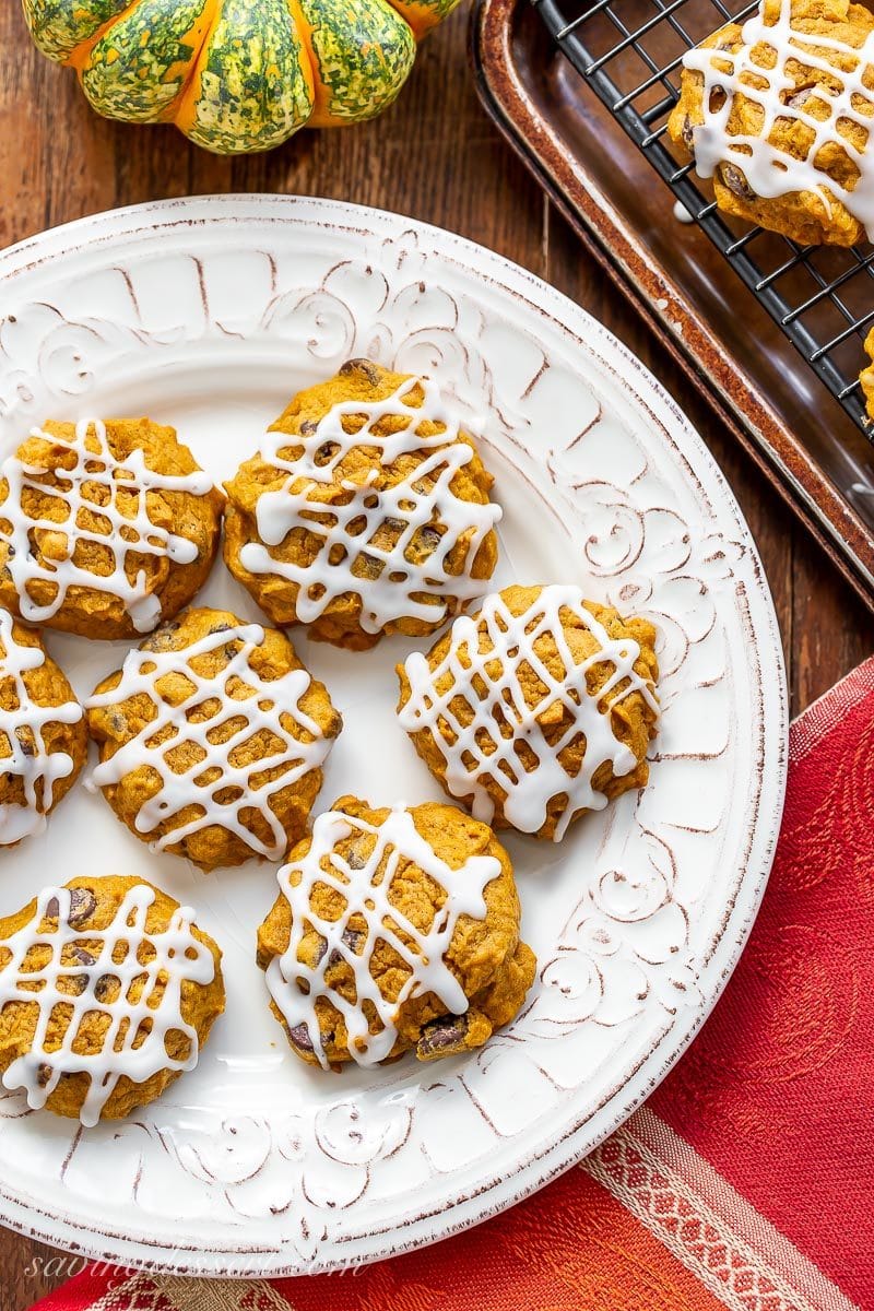 A plate of pumpkin chocolate chip cookies with a drizzled icing on top