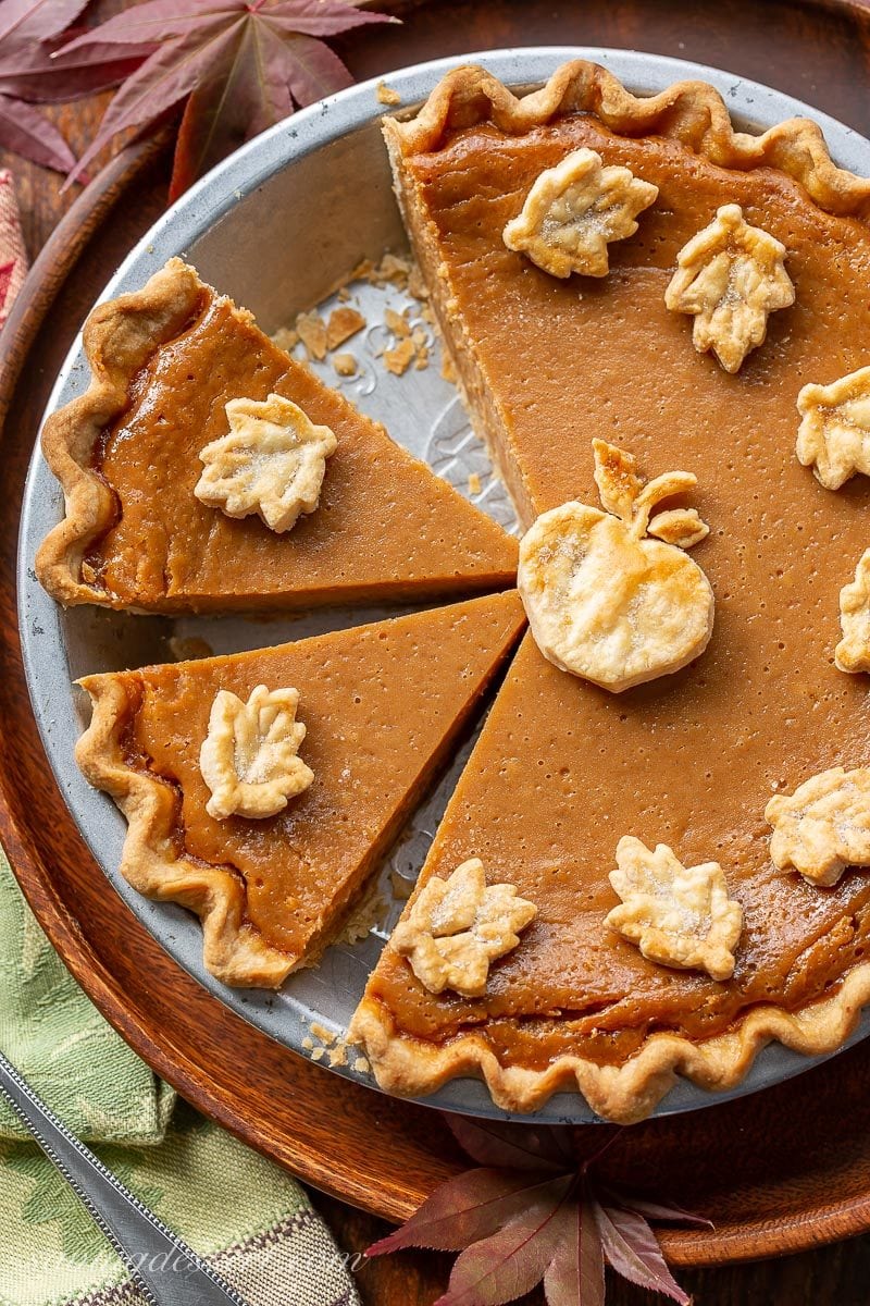 Sliced apple butter pie decorated with pastry crust cut-outs in the shape of leaves and an apple