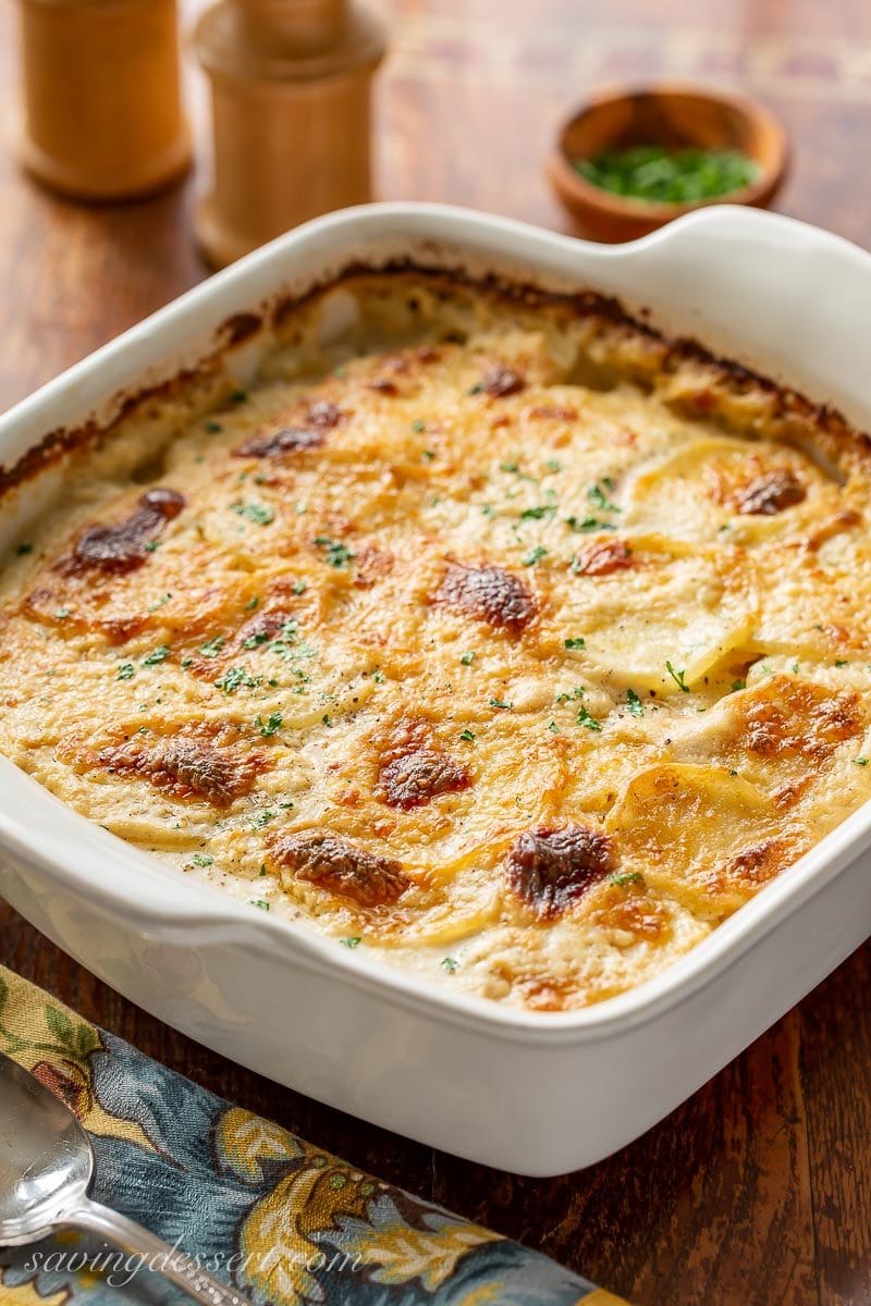 A square baker filled with hot Au Gratin Potatoes with Gruyere cheese