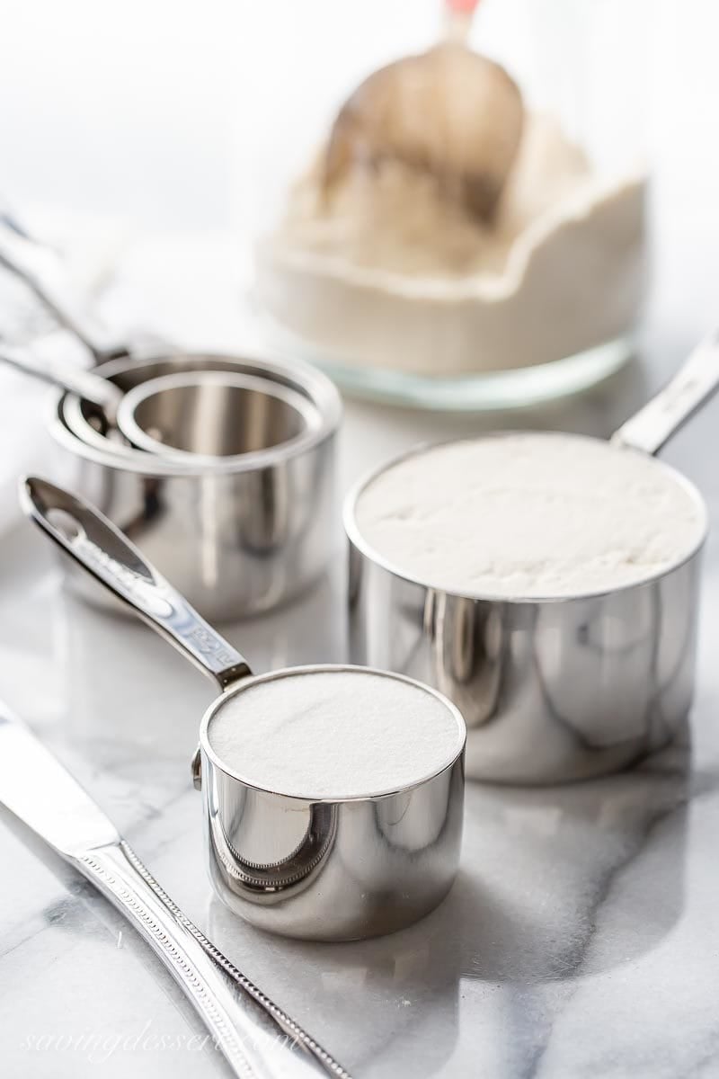 Measuring cups filled with flour and sugar as one of our best baking tips