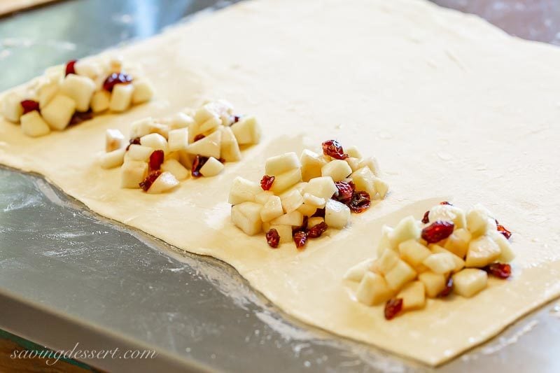 A piece of puff pastry rolled out and topped with a cranberry apple filling