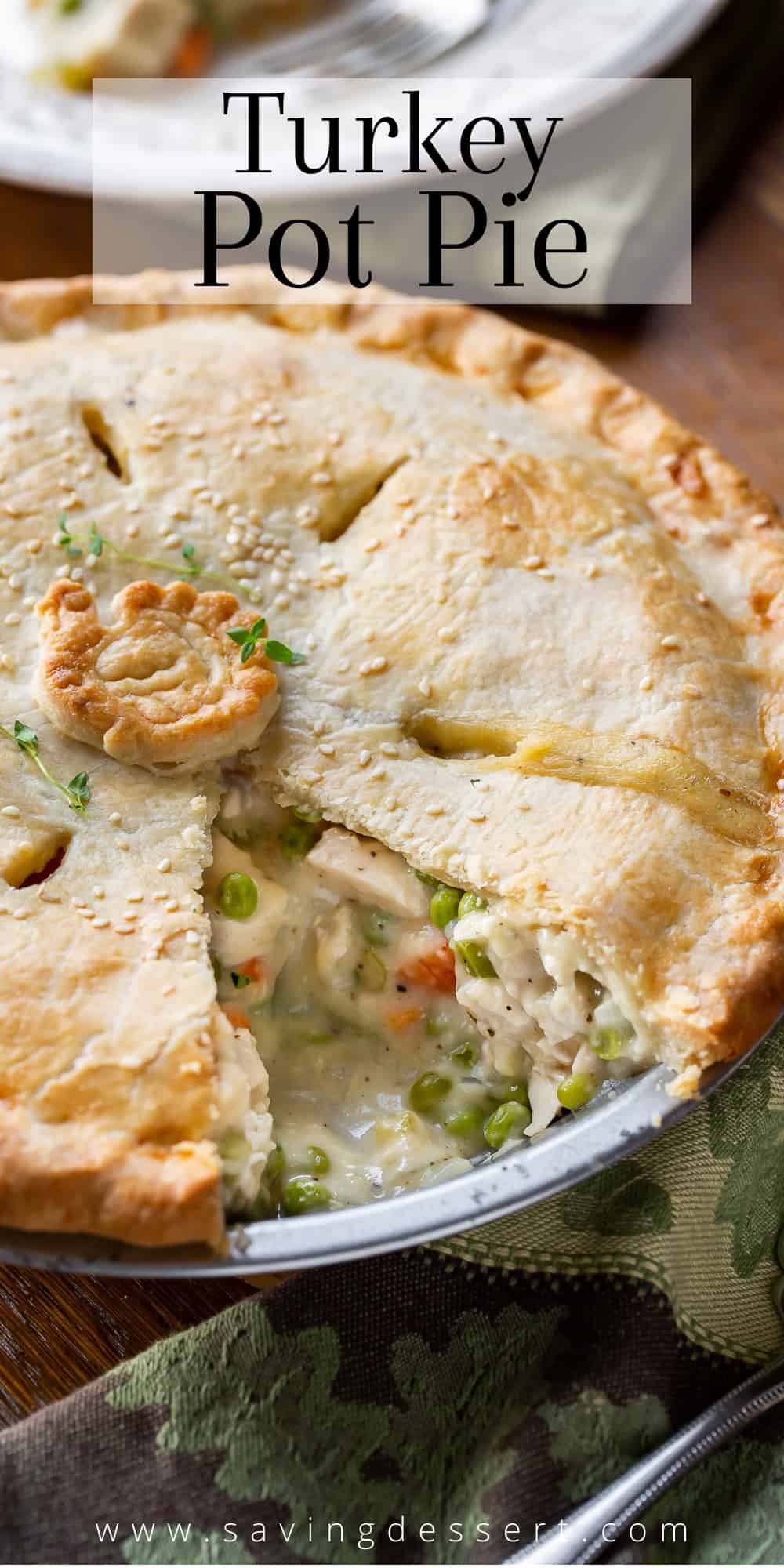 A close up of a sliced turkey pot pie with chunks of turkey and vegetables