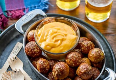 A small bowl of beer cheese dip served with pretzel nuggets