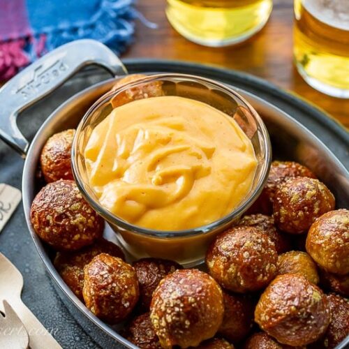 A small bowl of beer cheese dip served with pretzel nuggets