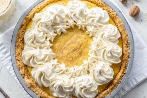 Creamy eggnog pie with swirls of whipped cream and nutmeg