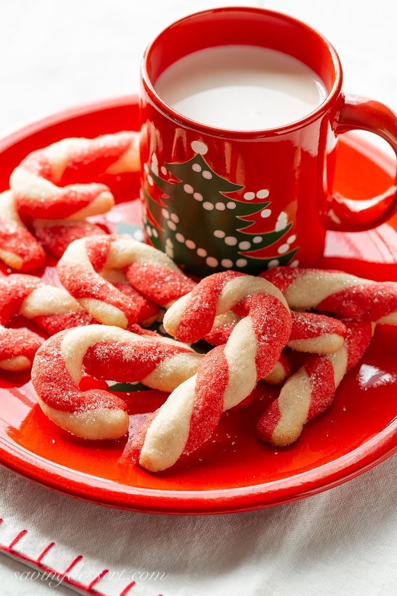 A plate of candy cane cookies with a glass of milk