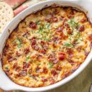 A small casserole dish with hot caramelized onion dip