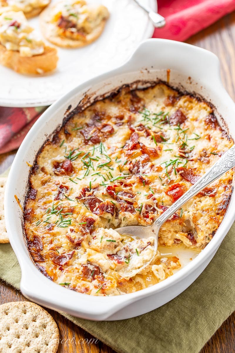 Hot caramelized onion dip in a casserole dish with a spoon