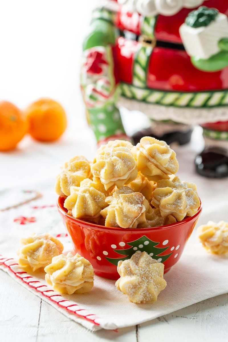 A bowl of orange cream star cookies dusted with powdered sugar