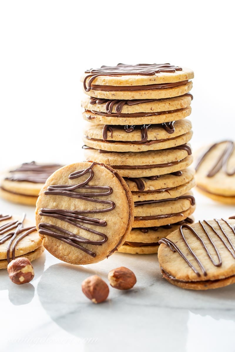 A stack of Hazelnut Nutella sandwich cookies with a decorative drizzle of chocolate on top 