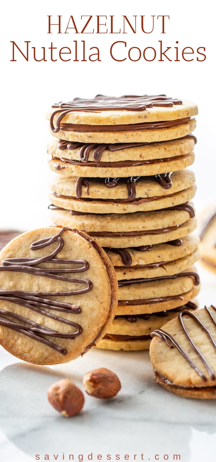 A stack of hazelnut cookies sandwiched with a smear of Nutella and topped with a chocolate drizzle 
