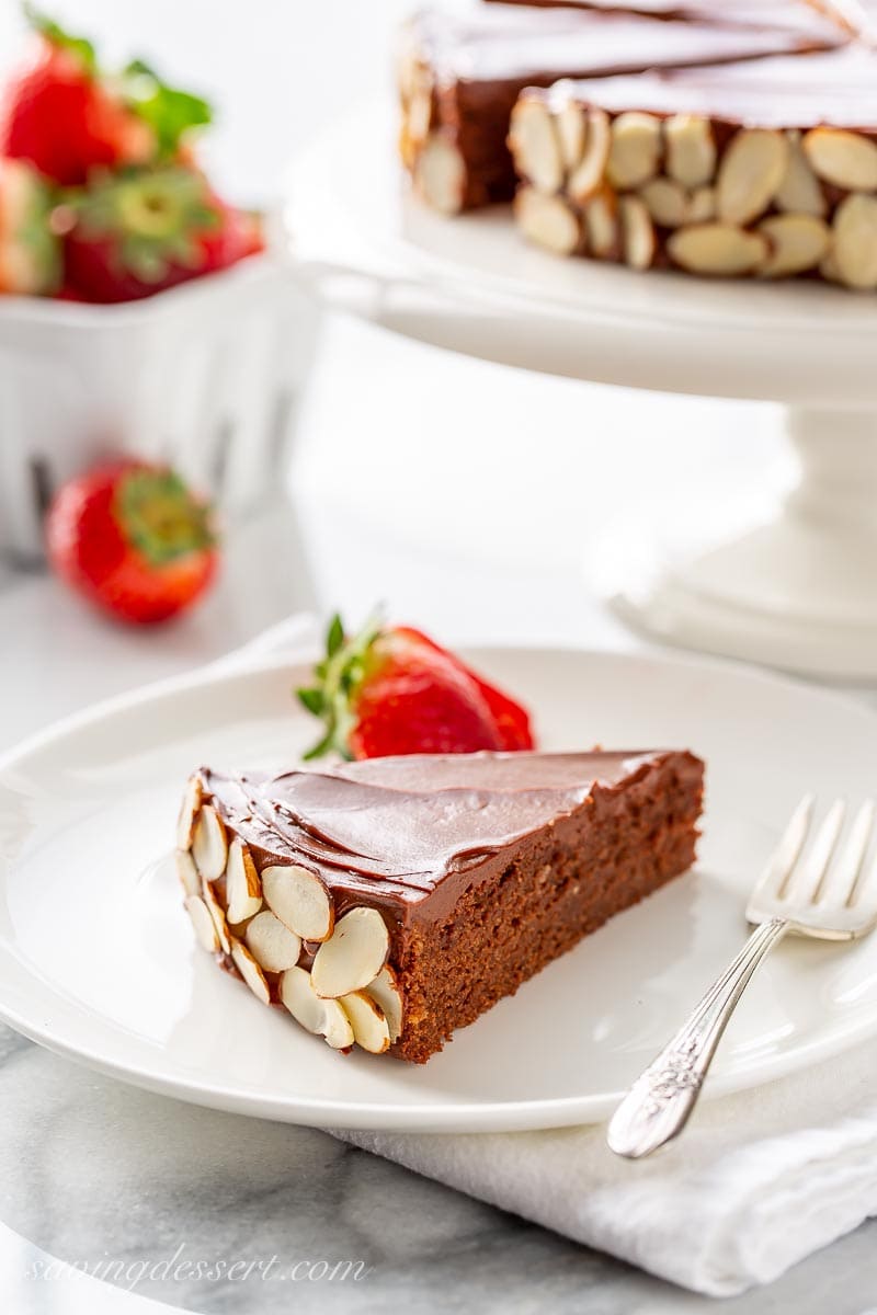 A slice of chocolate almond cake served with strawberries