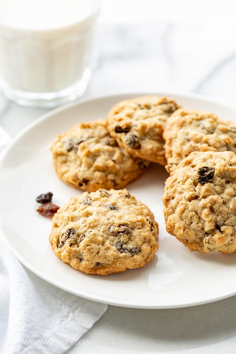 Oatmeal raisin cookies on a plate with a glass of milk