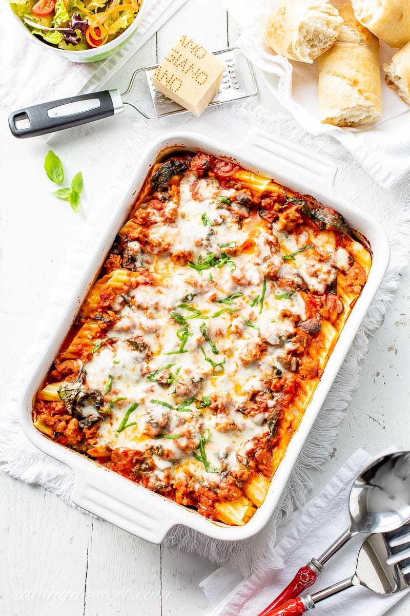 A casserole dish filled with stuffed manicotti shells topped with a meaty sauce