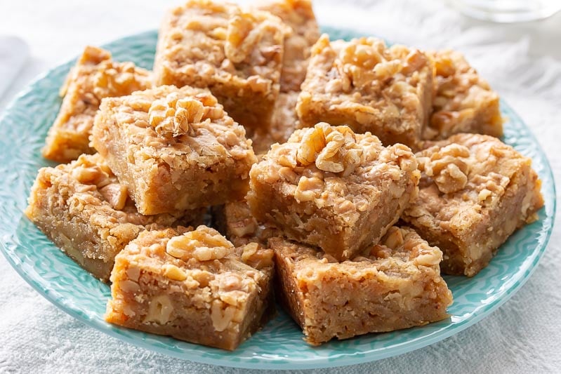 A plate filled with walnut toffee bars