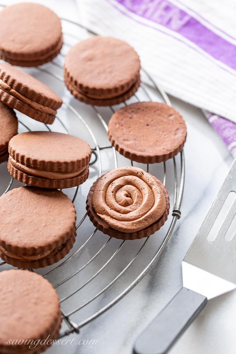 A cooling rack with a chocolate cookie topped with chocolate creme filling