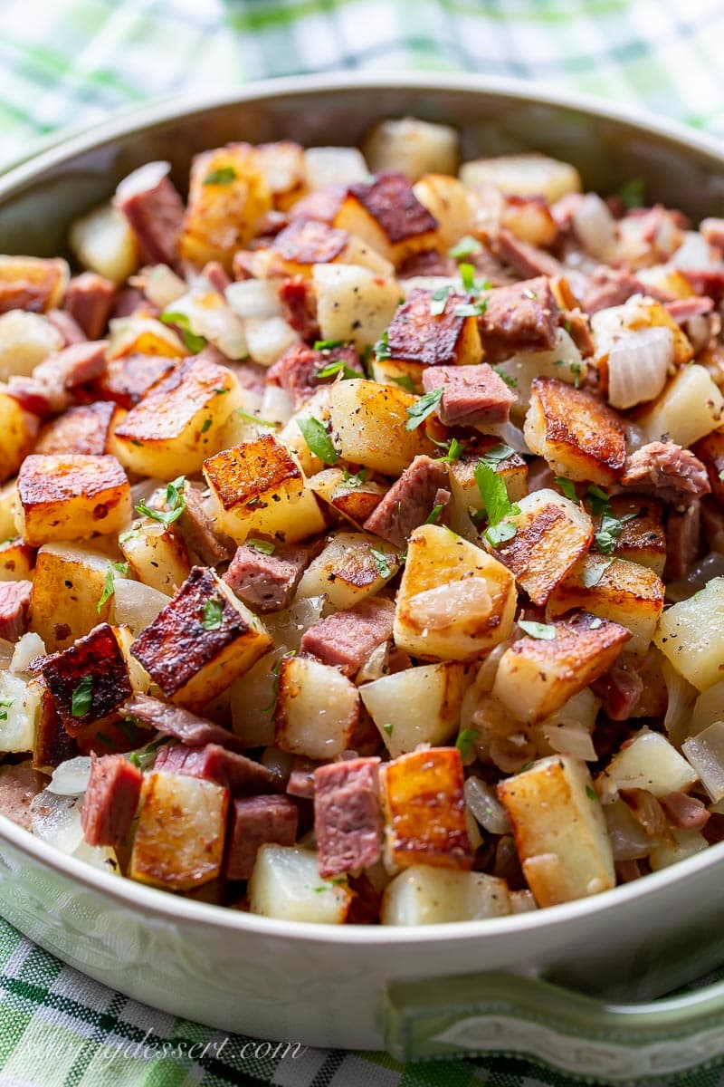 A serving bowl filled with breakfast hash garnished with parsley