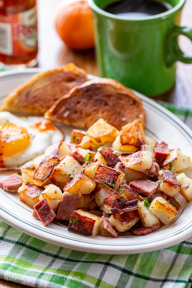 A plate of corned beef hash with a fried egg and toast