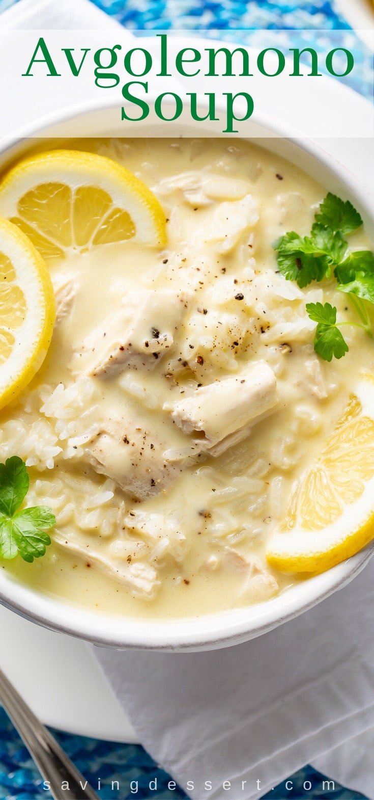 An overhead view of a bowl of Greek chicken and rice soup with lemons