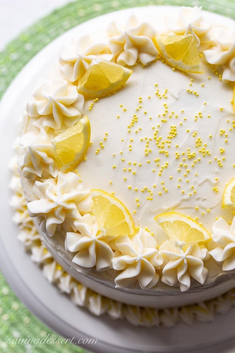 An overhead view of a lemon layer cake topped with yellow sprinkles