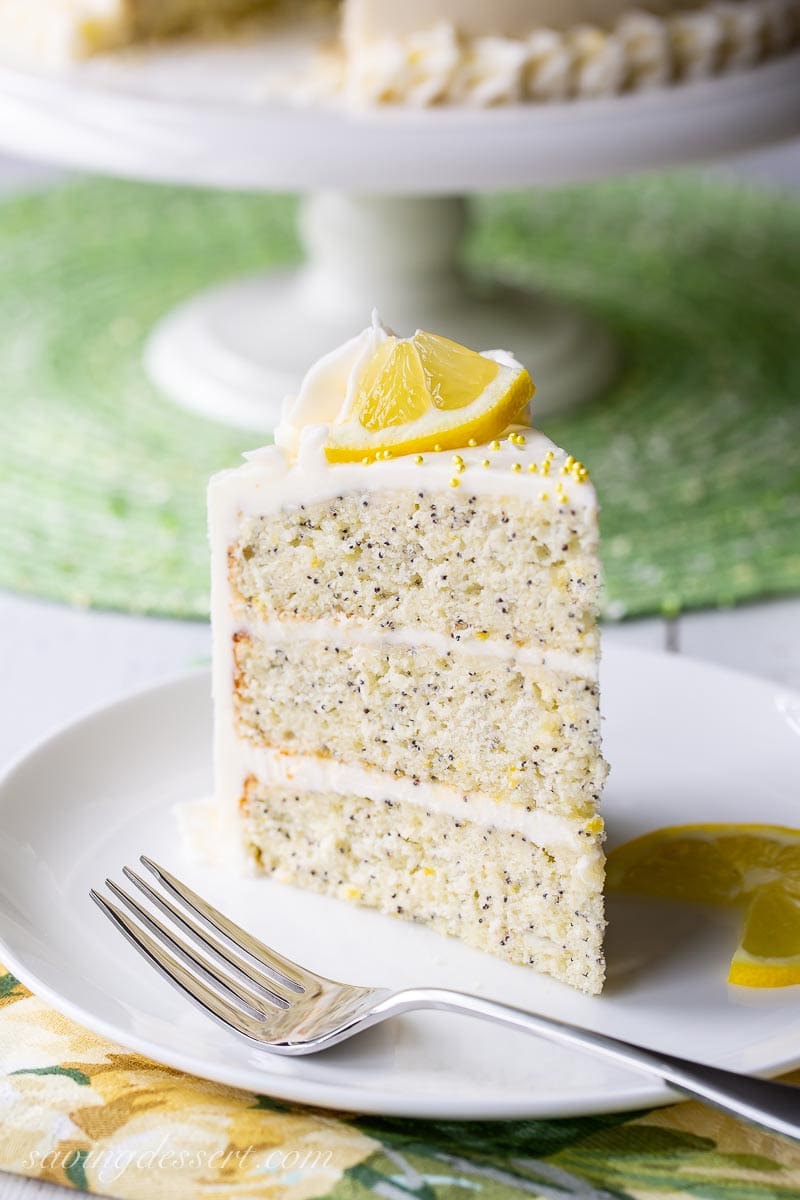 A slice of lemon poppy seed cake on a plate with a fork