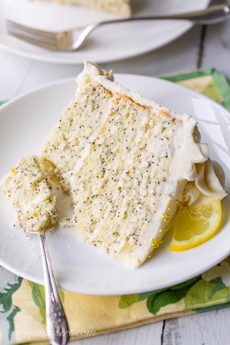 A slice of lemon poppy seed cake garnished with a sliced lemon