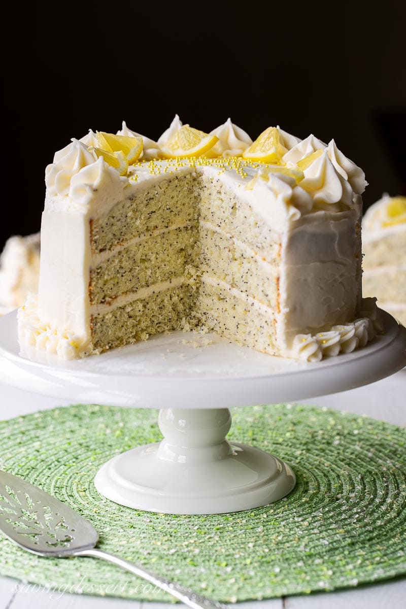 A sliced three layer lemon poppy seed cake with lemon cream cheese icing