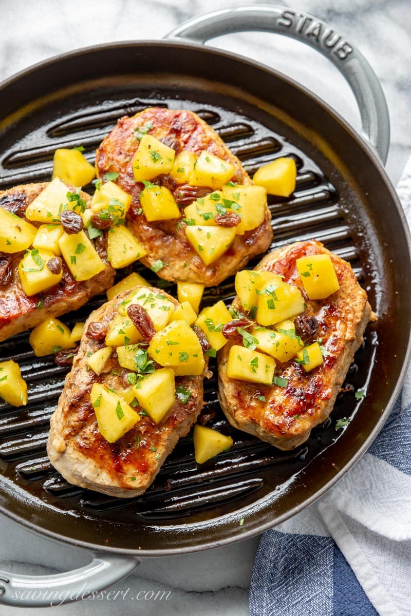 Grilled Pork chops topped with a peach Agrodolce in a skillet